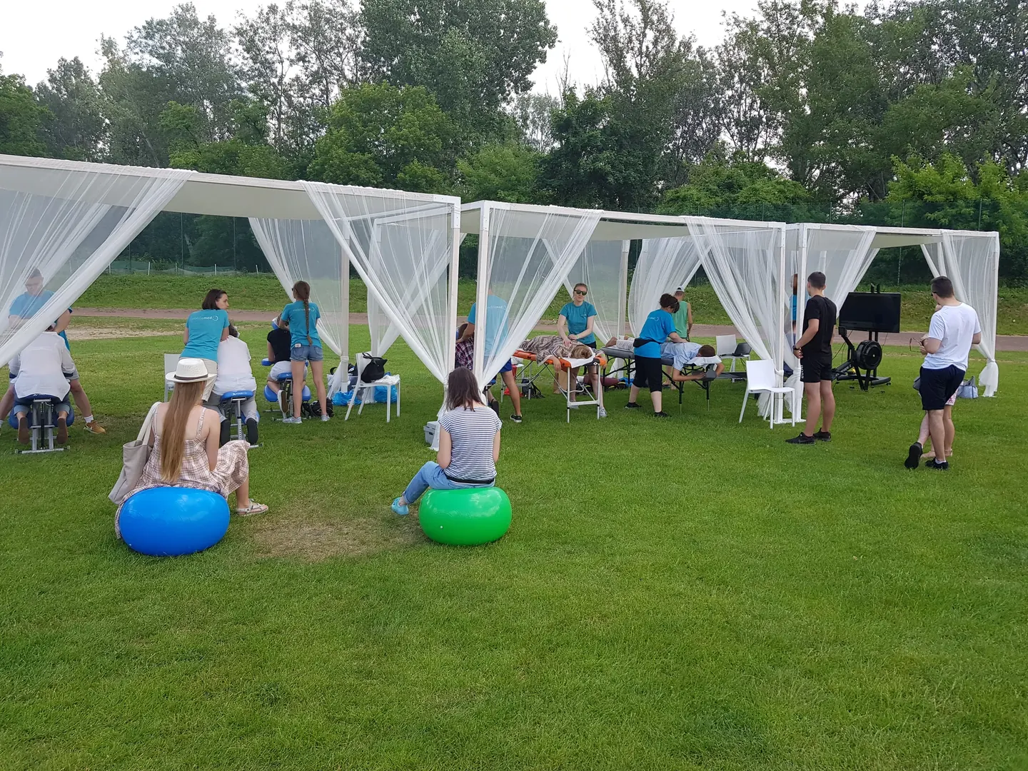Strefy zdrowia pod pawilonami, uczestnicy na piłkach